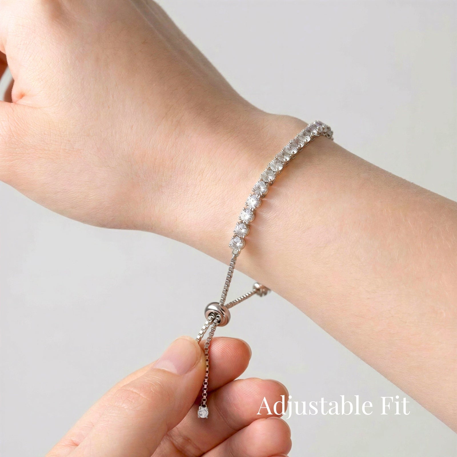 Moissanite tennis bracelet with slider adjustable clasp shown on wrist, demonstrating flexible fit for different wrist sizes